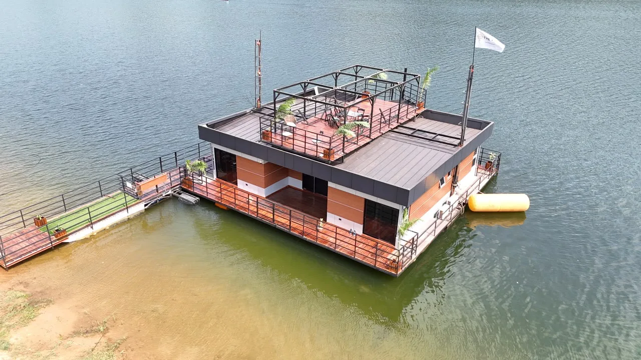 Aerial view of The Float on Lake Volta: a two-storey floating retreat with an open-air rooftop Sky Lounge and waterfront decks.